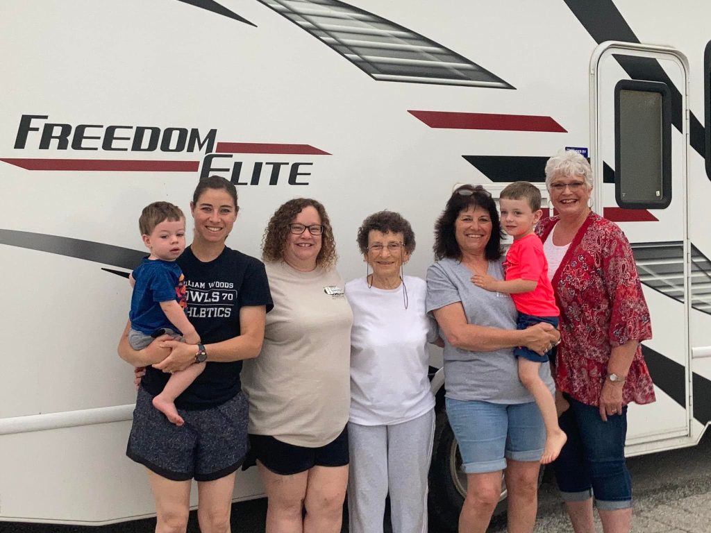 Edythe Nannemann stands with her family in front of an RV.