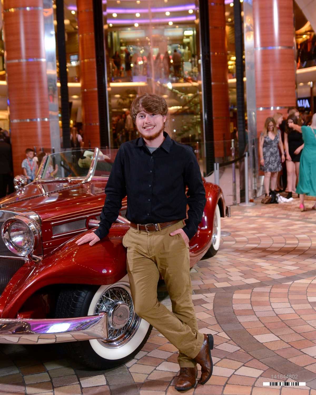 Cayden Pliler standing by a vintage car