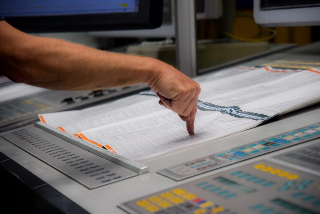 A hand pointing at a proof during the printing process