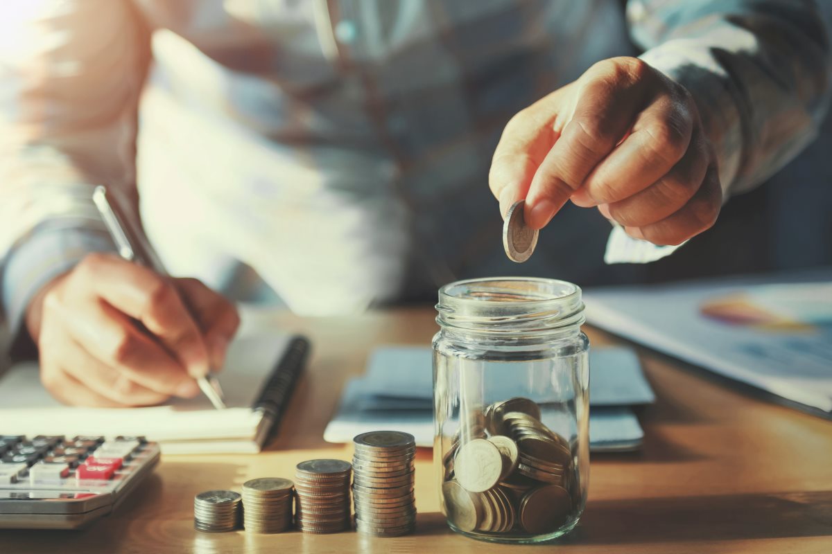 A man counting money and taking notes on a table