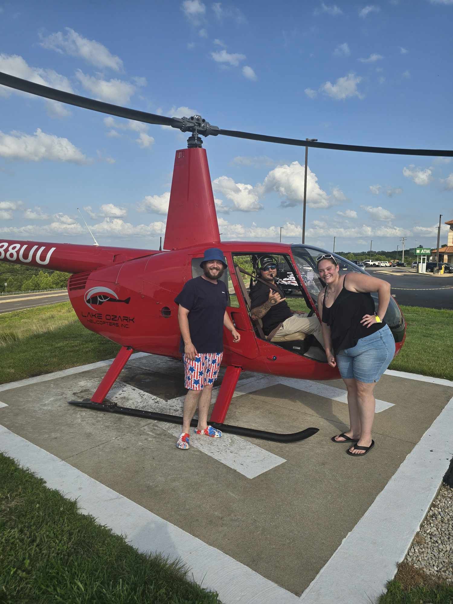 A helicopter on a heli pad with James Courtney standing next to it.