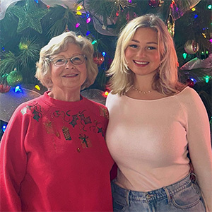 Alaysia Stremel with her family relative standing in front of a christmas tree