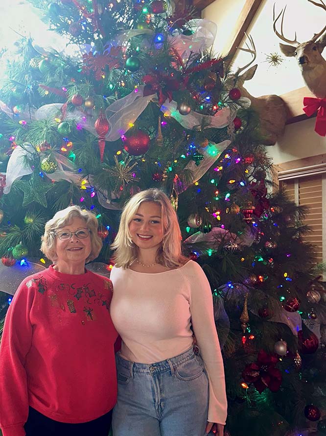 Alaysia with her family relative during christmas time in front of a christmas tree