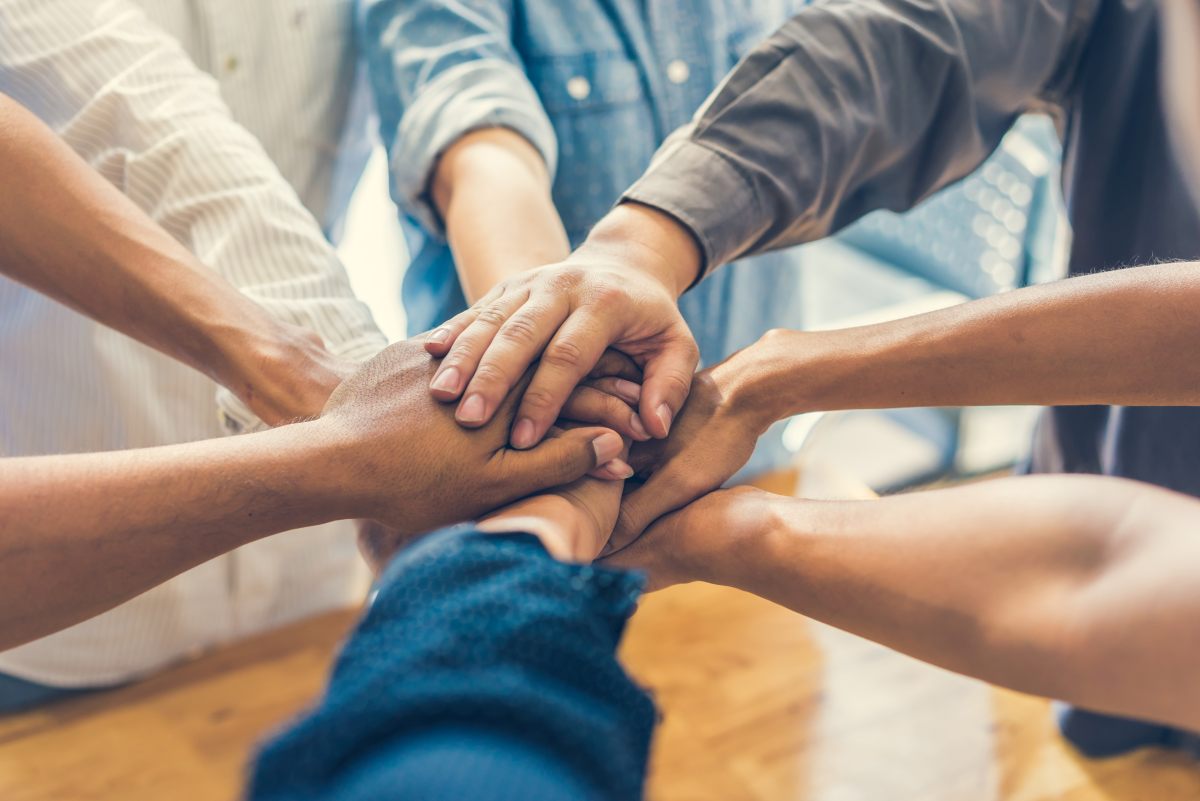 Employees putting their hands together