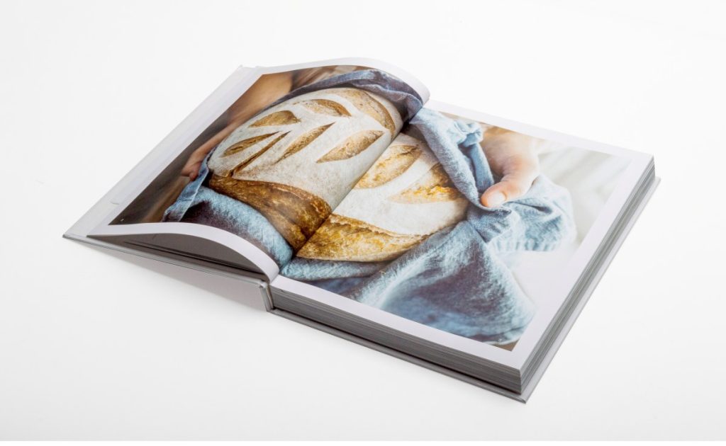 A coffee table book open on a white surface