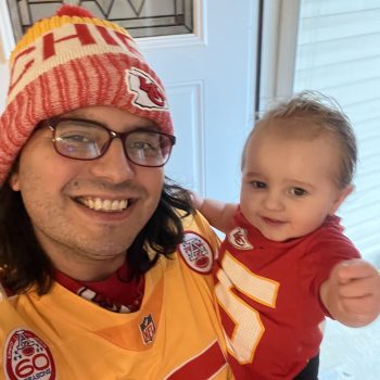 Nathan with a baby wearing chiefs jerseys