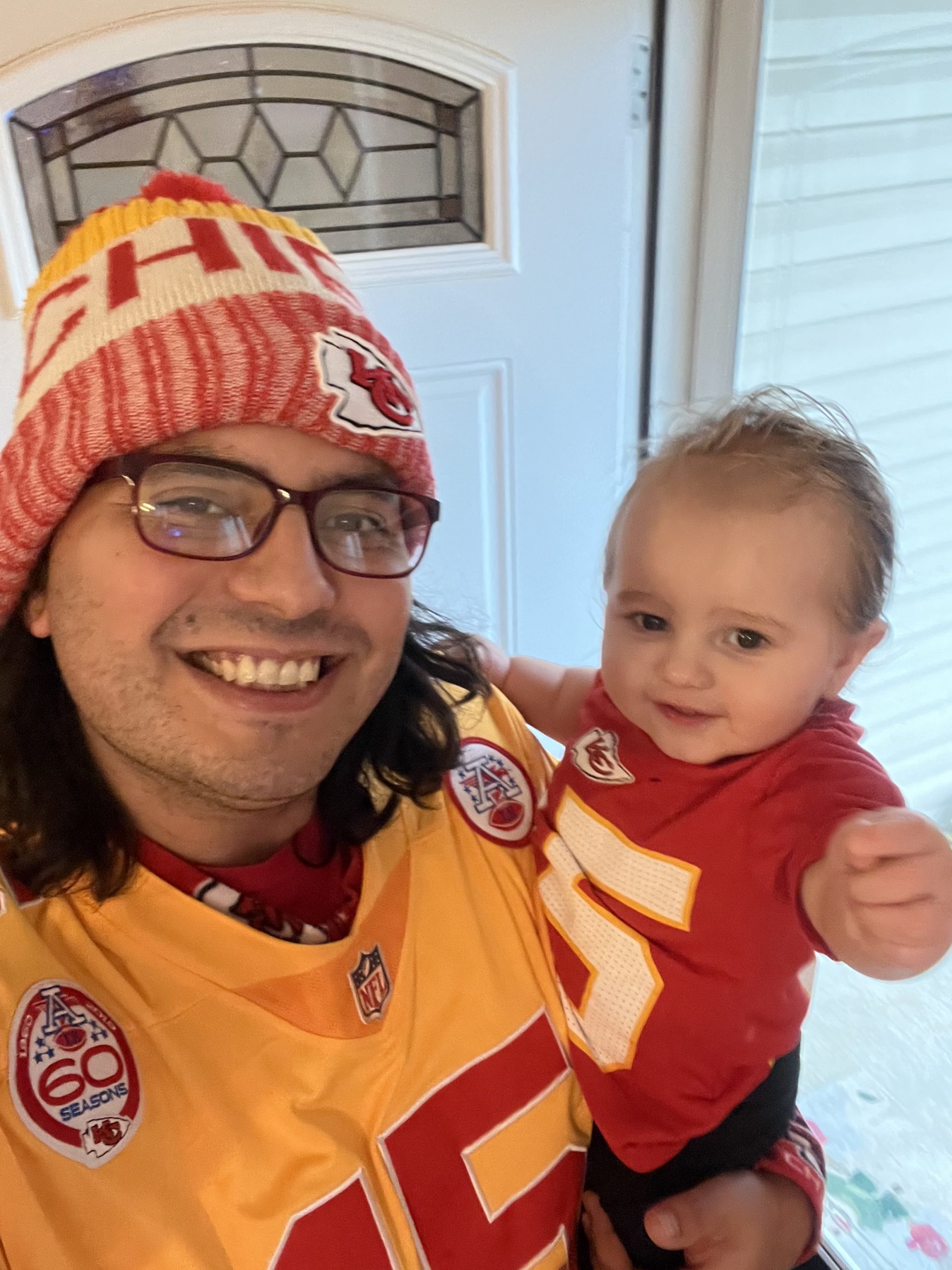 Nathan with a baby wearing chiefs jerseys