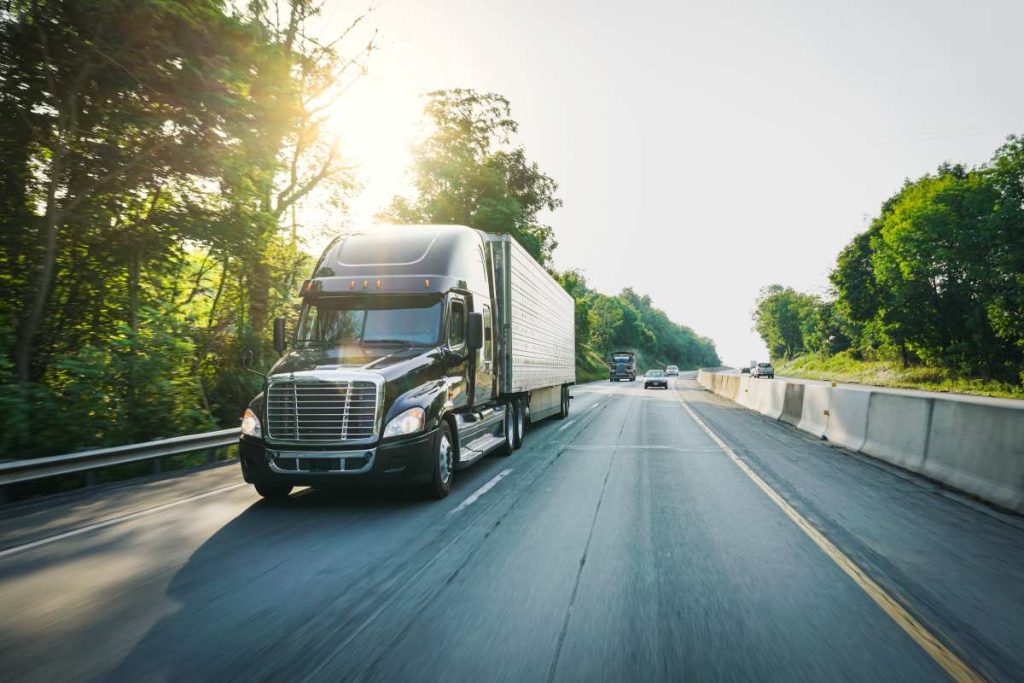 A semi truck driving down a highway